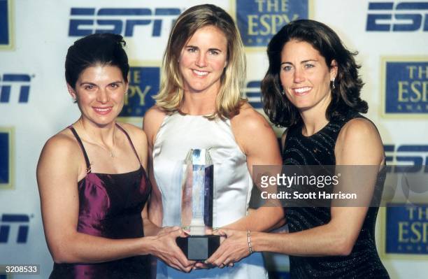 Left ti right; US Women's World Cup soccer team players Mia Hamm, Brandi Chastain, and Julie Foudy hold the award for Team of the Year on behalf of...