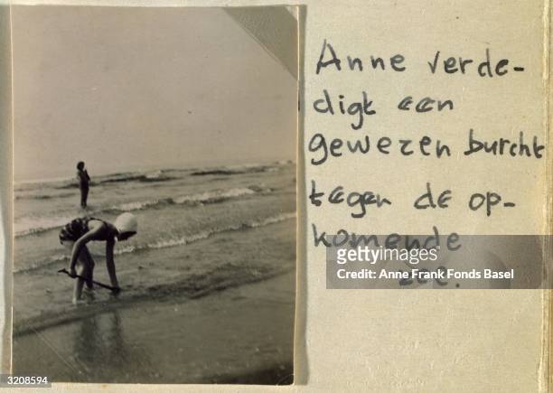 Anne Frank defends her sand castle from the sea as the tide comes in, Zandvoort, Holland. Placed next to her handwritten caption and taken from her...
