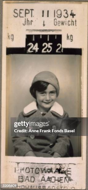 Portrait of Anne Frank taken in a photography booth with her weight and the date the photo was taken printed on the border, Aachen, Germany. From...