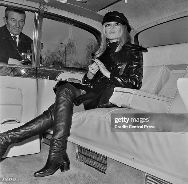 French actress Brigitte Bardot relaxes in the back of a limousine upon her arrival at London's Heathrow Airport. She has flown in from Paris to...