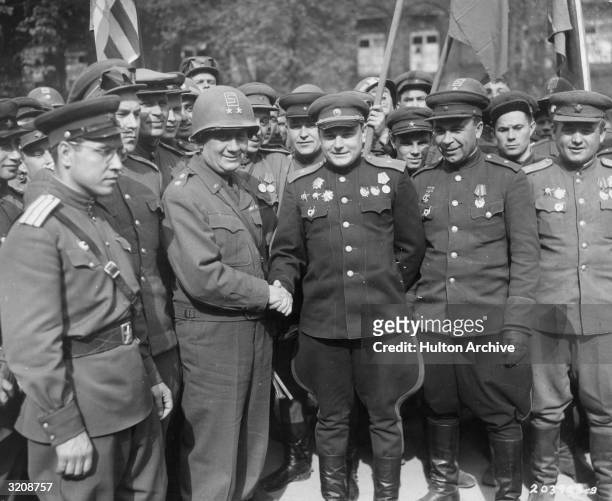 American Major-General Emil F. Reinhardt , Commanding General of the 69th Division, shakes hands with his Russian counterpart, Major-General Vladimir...