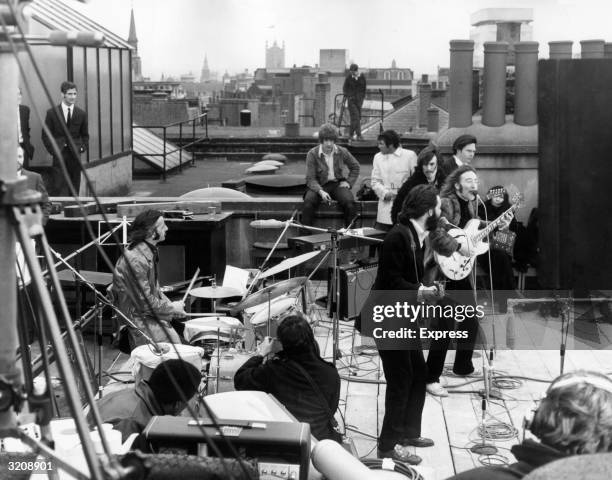 British rock group the Beatles performing their last live public concert on the rooftop of the Apple Organization building for director Michael...