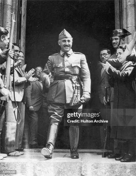 General Francisco Franco , chief of the Southern Rebel Army in Spain, walking out of a building through a group of cheering people.