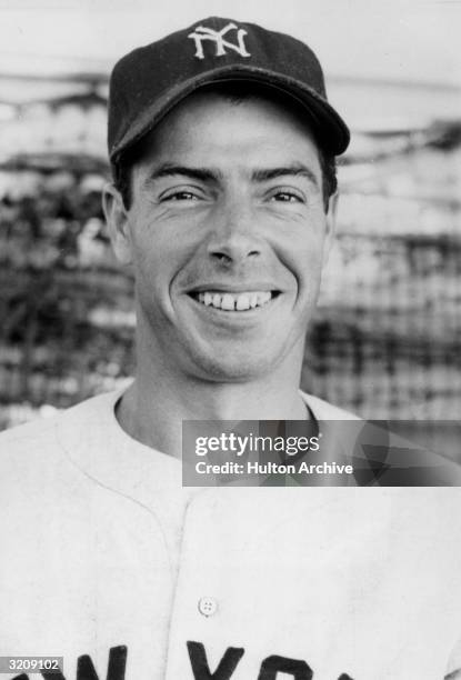 Headshot of New York Yankees baseball player Joe DiMaggio smiling in his uniform.