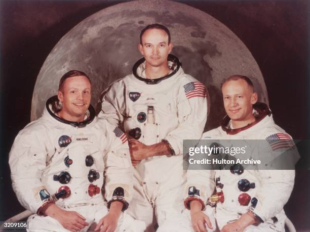Group publicity portrait of Apollo 11 astronauts Neil Armstrong, Michael Collins, and Edwin 'Buzz' Aldrin wearing spacesuits.