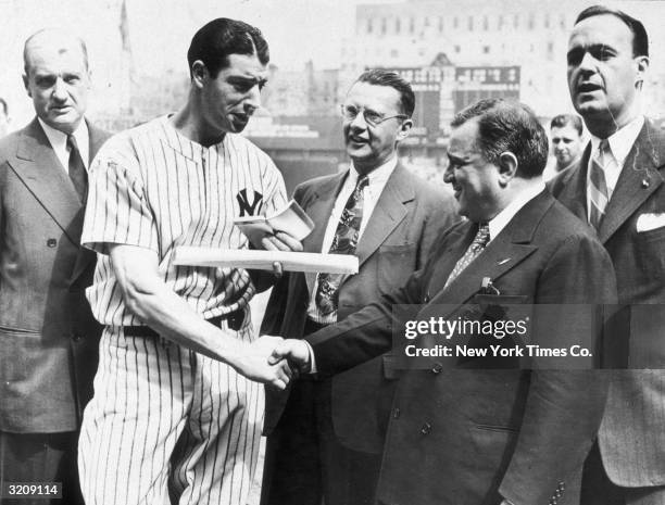 New York Yankees player Joe DiMaggio shakes hands with NYC mayor Fiorello La Guardia after receiving the award for most valuable player of the...