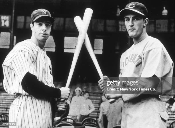 Heavy hitters Joe DiMaggio of the New York Yankees and Frank McCormick of the Cincinnati Reds pose with baseball bats crossed.