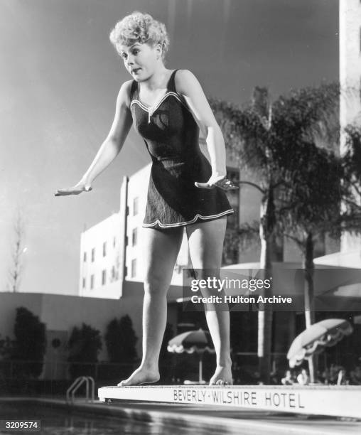 Full-length image of American actor Betty Hutton making a face while standing on the edge of a diving board, Beverly Wilshire Hotel, Hollywood,...