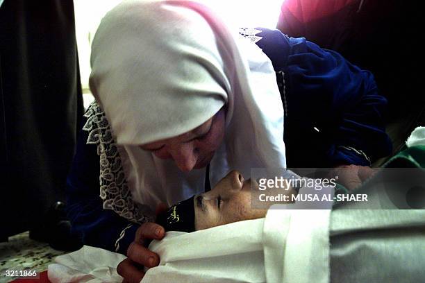The mother of 16-year-old Palestinian Nasser Issa Hajahjeh kisses 03 April 2004 his body prior to his funeral in the southern West Bank town of...
