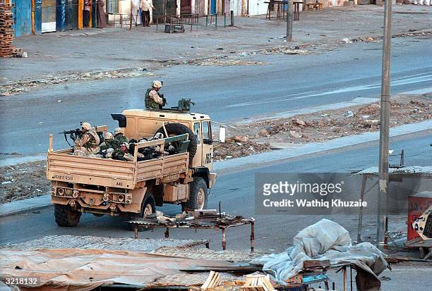 Troops patrol the deserted streets of the sprawling Shia slum of Sadr City at sunset after a day of tense clashes across the country with supporters...