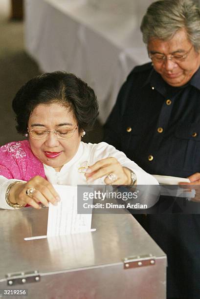 Indonesia President Megawati Sukarnoputri votes, accompanied by her husband Taufik Kiemas , on April 5, 2004 in Jakarta, Indonesia. Around 147...