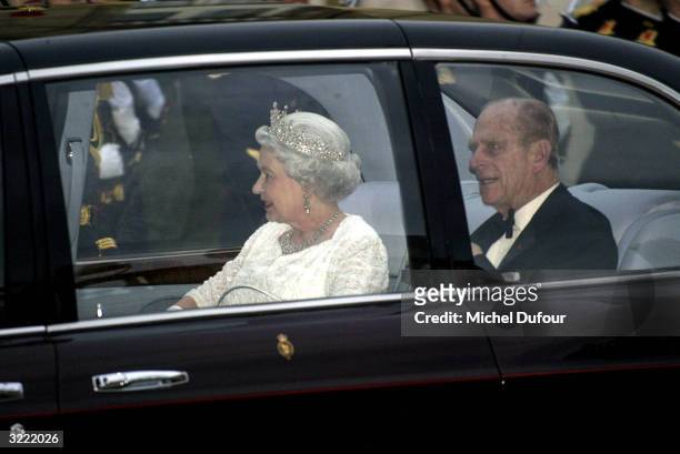 Queen Elizabeth II and the Duke of Edinburgh arrive by royal car as they attend a reception in their honor at Musee du Louvre April 5, 2004 in Paris,...