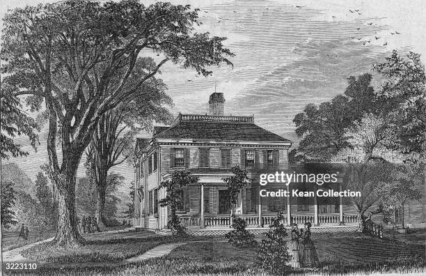 Exterior view of the home of American poet Henry Wadsworth Longfellow, Cambridge, Massachusetts, 1860s. Two women stand in the foreground while a...