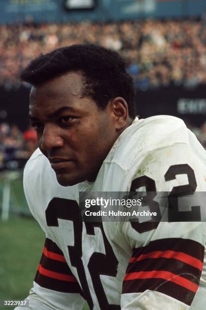 Cleveland Browns fullback Jim Brown sits on the bench during a game.