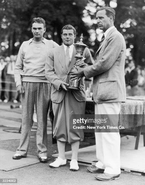 Stanford University student Lawson Little accepts the National Amateur Golf Championship trophy from Prescott Bush, President of the United States...