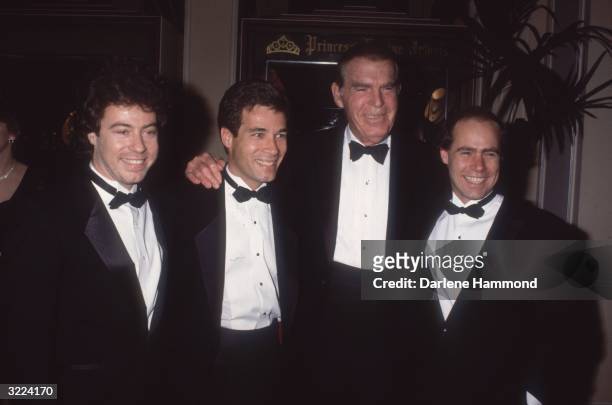 American actor Fred MacMurray poses with the actors who played his sons on the television series, 'My Three Sons,' during a University of Southern...