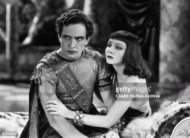 French-born actor Claudette Colbert clings to American actor Fredric March in a still from director Cecil B. DeMille's film, 'The Sign of the Cross'....