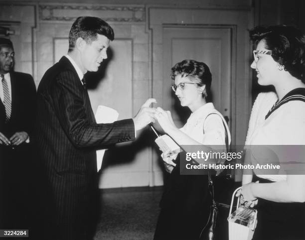 Senator John F. Kennedy helps a coed to click her pen so that he can sign her copy of his book, 'Profiles in Courage,' Portland State College ,...