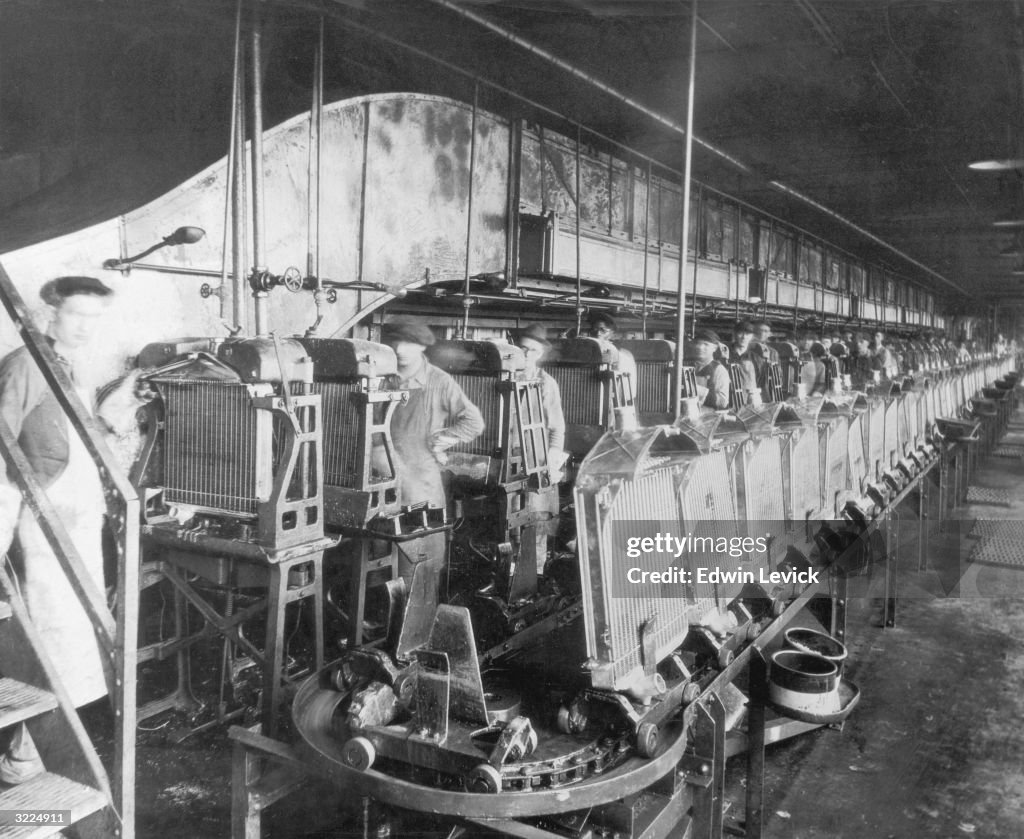 Car Radiator Installation Assembly Line Automobile workers making car radiators on an assembly line in a ...