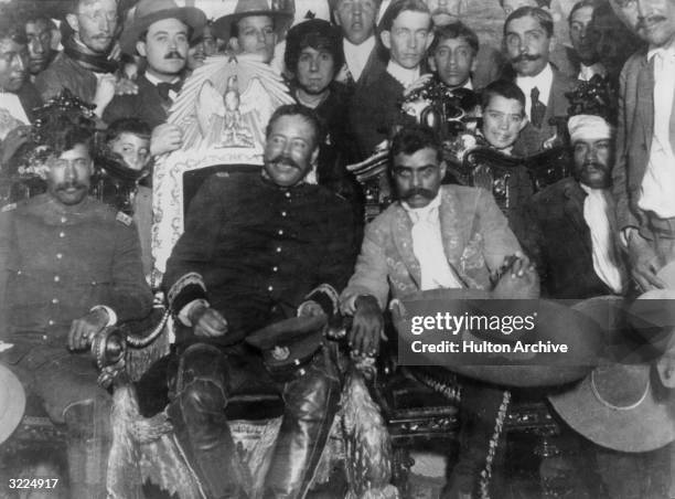 Mexican revolutionaries Pancho Villa and Emiliano Zapata sit with Tomas Urbina and Otilio Montano .