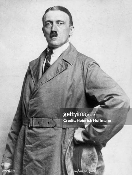 Studio portrait of dictator and leader of the German Nazi movement Adolf Hitler posing with his hand on his hip in an overcoat, and a shirt and tie.