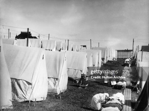Nurses care for victims of a Spanish influenza epidemic outdoors amidst canvas tents during an outdoor fresh air cure, Lawrence, Massachusetts.