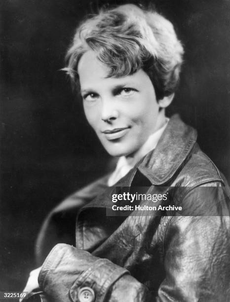 Studio headshot portrait of American aviator Amelia Earhart , the first woman to complete a solo transatlantic flight, wearing a leather jacket.