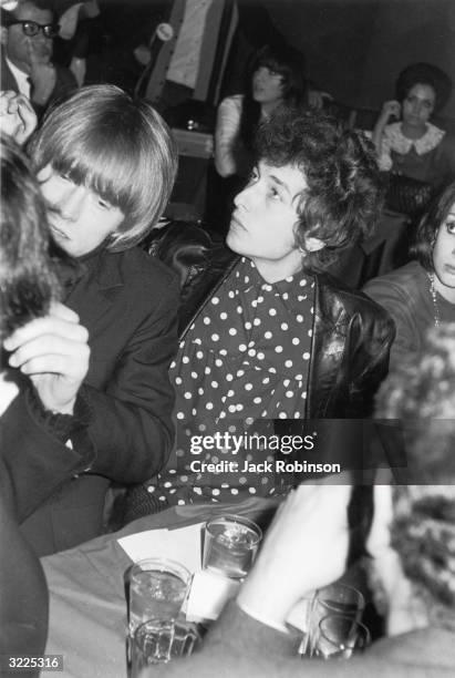 American singer and songwriter Bob Dylan and British rock musician Brian Jones sit at a table during a record release party for the Young Rascals,...