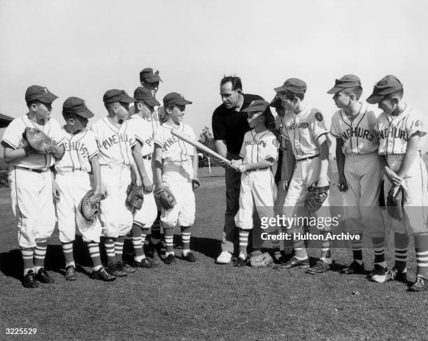 American baseball player and coach Yogi Berra showing the Pinehurst Lions Club Little League baseball team how to hold a baseball bat, Pinehurst,...