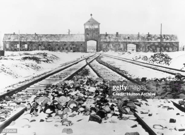 Snow-covered personal effects of those deported to the Auschwitz concentration camp in Poland litter the train tracks leading to the camp's entrance.