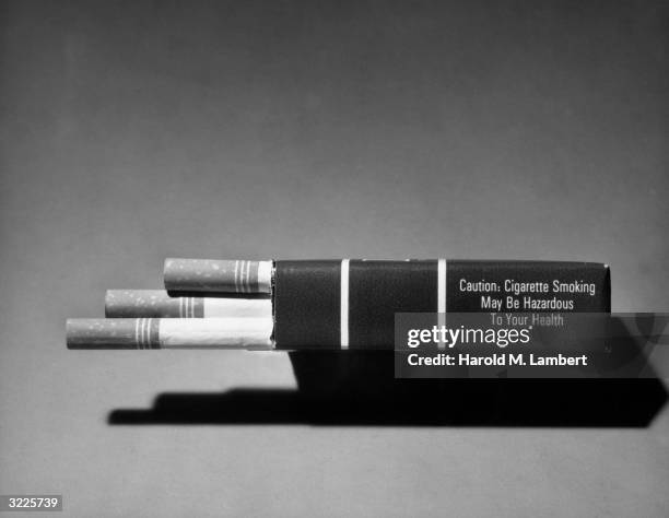 Still-life of the side of a pack of cigarettes with a health hazard label required on all cigarette packages from Jan 1, 1966. It reads: 'Caution:...