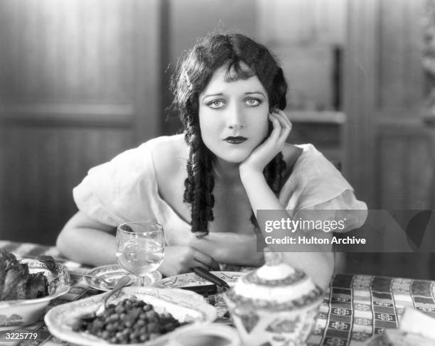 American actor Joan Crawford gazes at the camera, propping her chin on her hand, in a still from director William Nigh's film, 'The Law of the...