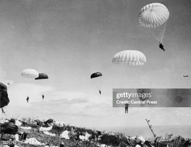 American paratroops of the 503rd Regiment drop on the bomb-shattered terrain of the island of Corregidor in the Philippines. The air warriors quickly...
