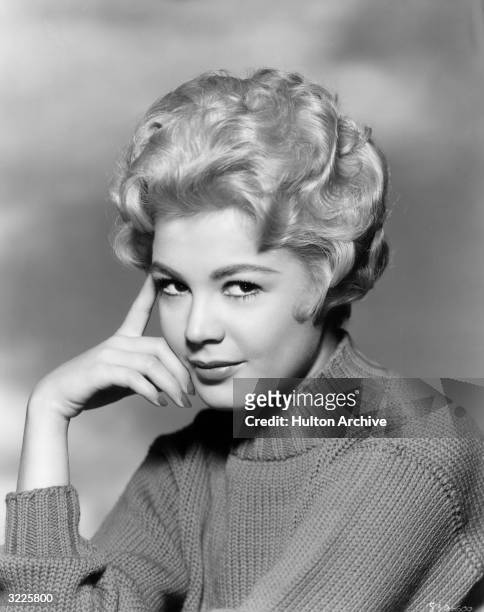 American actor Sandra Dee wearing a mock turtleneck sweater and resting her hand on her head in a promotional headshot portrait for director Delmer...
