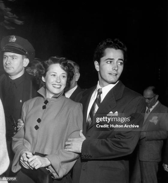 Married American actors John Derek and Pati Behrs arrive at a theater to see director George Cukor's film, 'Born Yesterday'. Derek is walking behind...