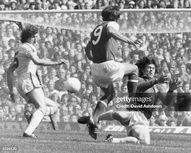 Leeds players, Paul Hart and goalkeeper, Harvey attempt to block an attack on the Leeds goal by Arsenal's Malcolm MacDonald.