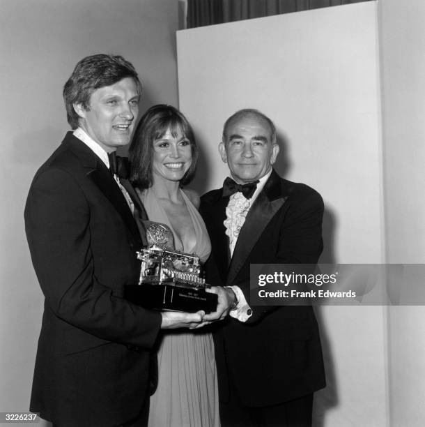 American actors Alan Alda, Mary Tyler Moore, and Ed Asner holding a Television Critics Circle award after the ceremony, Los Angeles, California. The...