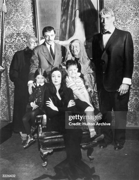 Group portrait of the cast of the television series, 'The Addams Family,' in costume. Standing : Jackie Coogan , John Astin, Blossom Rock, and Ted...