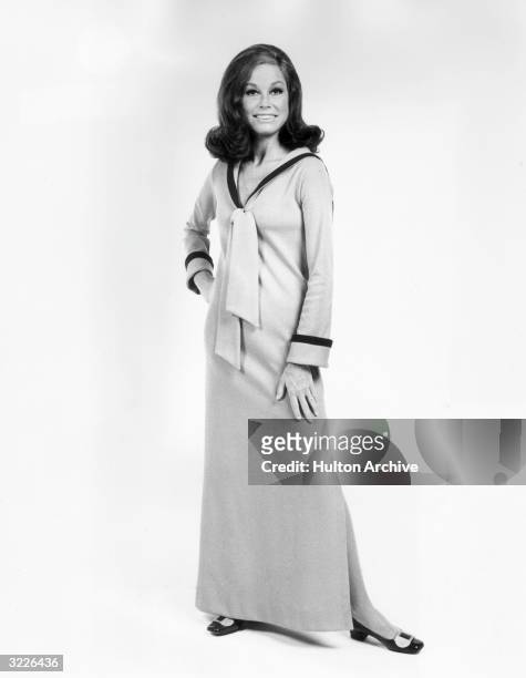 Full-length studio portrait of American actor Mary Tyler Moore. She is wearing a long sleeved, full-length dress which has a nautical collar.