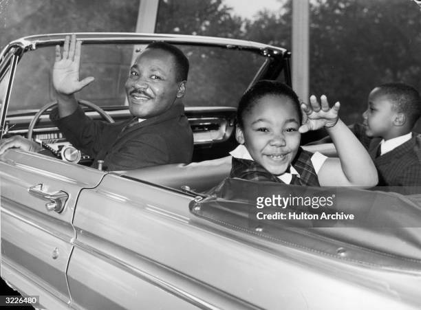 American civil rights leader Martin Luther King Jr. Waves with his children, Yolanda and Martin Luther III, from the 'Magic Skyway' ride at the...