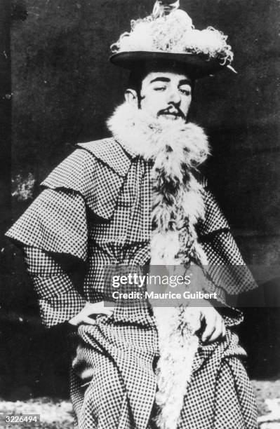 Portrait of French painter and graphic artist Henri Toulouse-Lautrec cross-dressed as a woman in a plumed hat and an ostrich boa over a frock coat,...