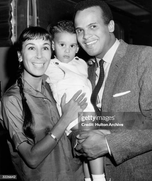 Portrait of American actor and singer Harry Belafonte posing with his wife, American dancer Julie Robinson, and their 22 month-old son, David, upon...