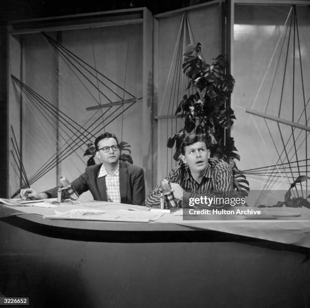 American actor Andy Griffith sits behind a desk with American television host Steve Allen, on the set of the television series 'The Steve Allen Show'.