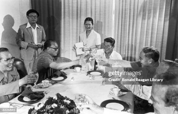 President Ronald Reagan smiles as he drinks a toast with Chinese prime minister Zhao Ziyang and other officials at a dinner during the Cancun...
