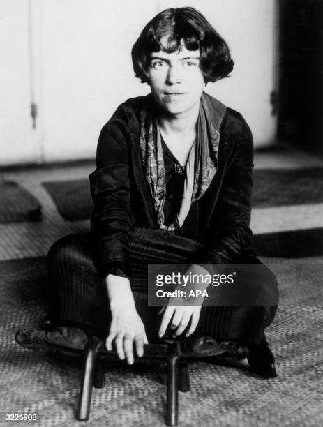 Portrait of American anthropologist Dr. Margaret Mead, assistant curator of the American Museum of Natural History, wearing a dress and sitting...