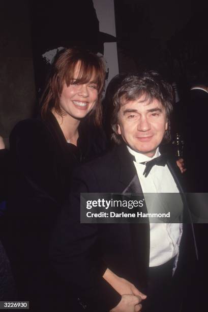 British actor Dudley Moore walking with his third wife, Brogan Lane, at an awards show.