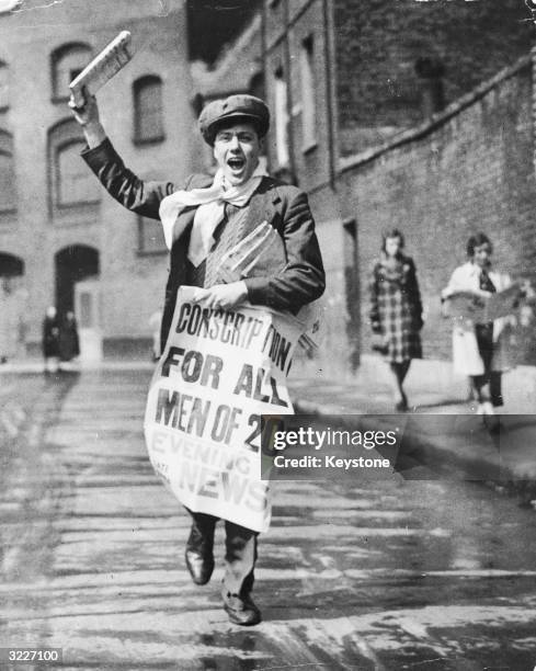 Newspaper boy with a poster calling for the conscription of all 20-year-old men during World War II.