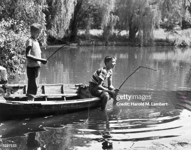 https://media.gettyimages.com/id/3227133/photo/two-boys-in-a-wooden-rowboat-fish-in-a-river-with-homemade-stick-fishing-poles-one-boy-stands-in.jpg?s=612x612&w=gi&k=20&c=aS8TQ9tqJL3BTng3aqQbi3oBNOxDW_guYECWV1uMJtU=