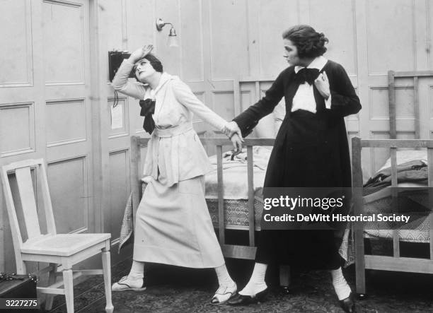 American actor and dancer Irene Castle strikes a melodramatic pose, as an unidentified actor grabs her arm, in a still from the silent film 'Patria'.