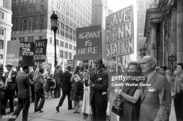 American writer Jane Jacobs and architect Philip Johnson stand with picketing crowds outside Penn Station to protest the building's demolition, New...